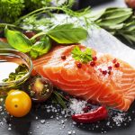 Świeży filet z łososia z ziołami, solą, oliwą i warzywami — fotografia produktowa